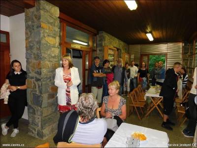 Na terase se již shromáždili hosté a Bára je zve do podzemí.